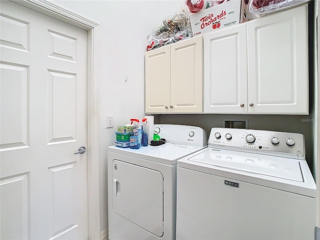 laundry room with cabinets and washer and clothes dryer