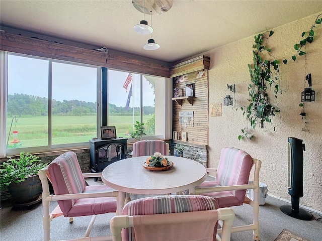 sunroom with a rural view and a wood stove