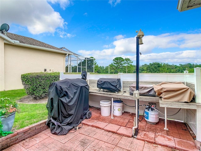 view of patio / terrace with glass enclosure and a grill