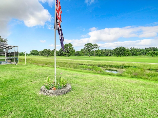 view of yard with glass enclosure and a rural view