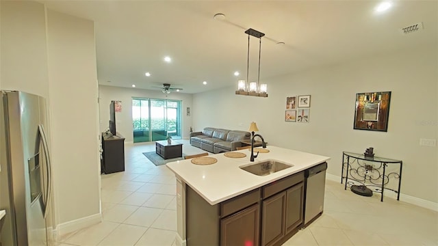 kitchen featuring appliances with stainless steel finishes, pendant lighting, ceiling fan, a center island with sink, and sink