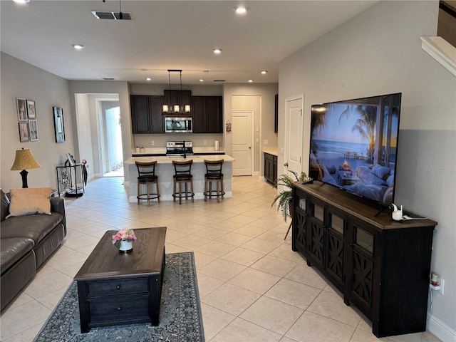 living area featuring light tile patterned floors, baseboards, visible vents, and recessed lighting