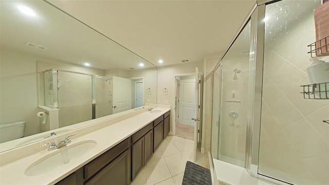 bathroom with double vanity, a stall shower, tile patterned flooring, and visible vents