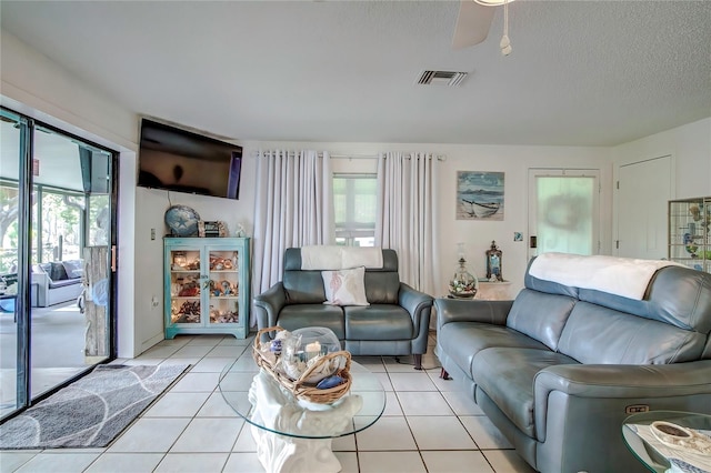 tiled living room with a textured ceiling and ceiling fan