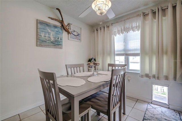 dining room featuring a textured ceiling, a healthy amount of sunlight, ceiling fan, and light tile patterned floors