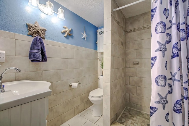 bathroom with a textured ceiling, tile walls, toilet, and curtained shower