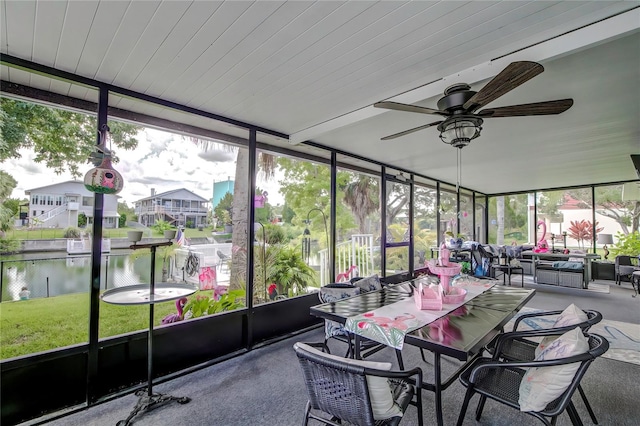 sunroom / solarium featuring a water view and ceiling fan