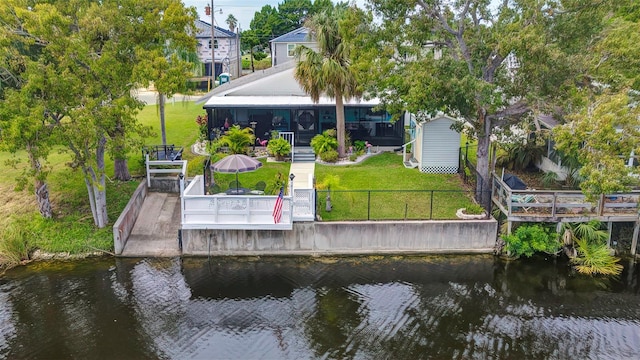 dock area featuring a patio, a lawn, and a water view