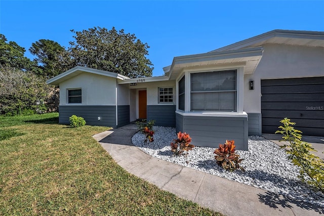 ranch-style house with a garage and a front lawn