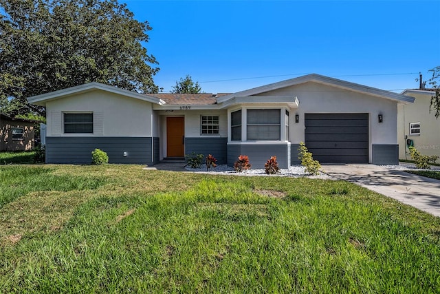 ranch-style home with a garage and a front lawn