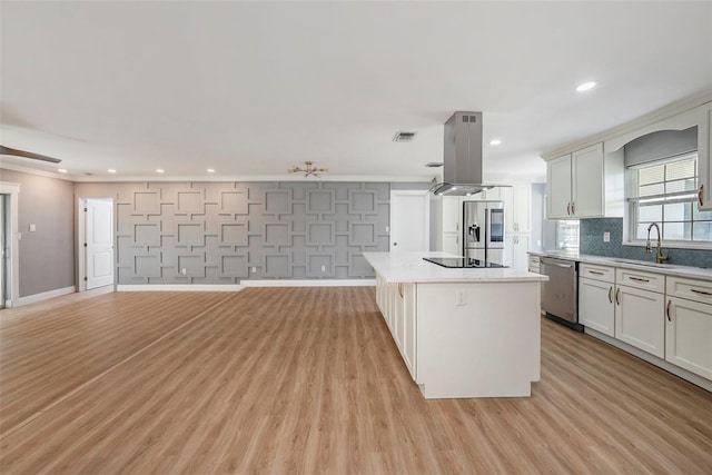 kitchen featuring island range hood, light hardwood / wood-style flooring, appliances with stainless steel finishes, and a kitchen island