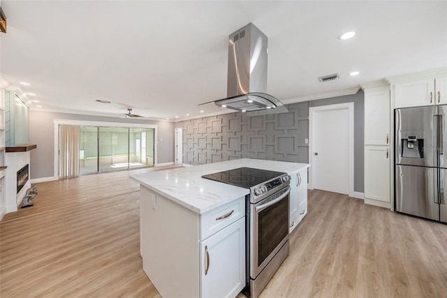 kitchen with stainless steel appliances, light stone counters, white cabinets, and extractor fan