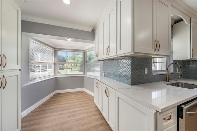 kitchen with light hardwood / wood-style flooring, crown molding, sink, white cabinetry, and light stone counters