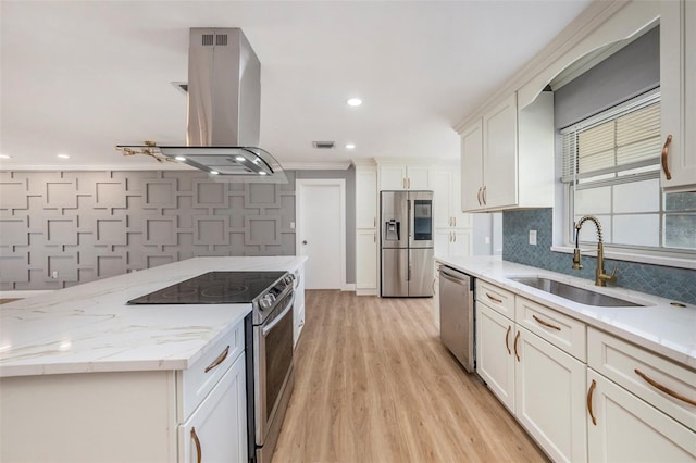 kitchen featuring island exhaust hood, stainless steel appliances, sink, light wood-type flooring, and white cabinets