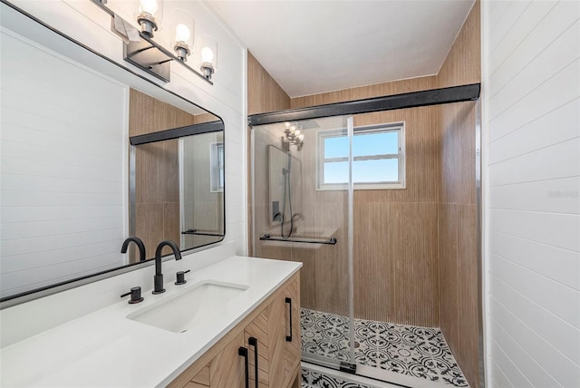 bathroom featuring a shower with door and vanity