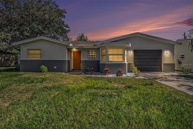 single story home with a garage and a lawn