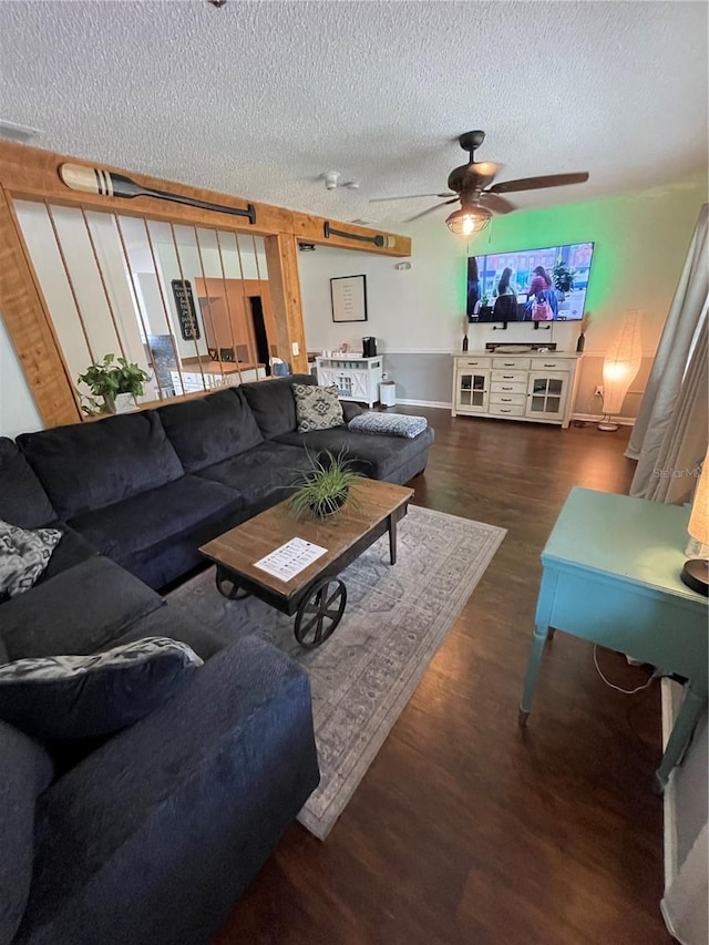 living room featuring ceiling fan, a textured ceiling, and dark hardwood / wood-style floors