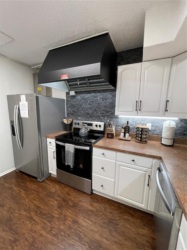 kitchen featuring white cabinets, stainless steel appliances, wall chimney exhaust hood, and dark hardwood / wood-style flooring