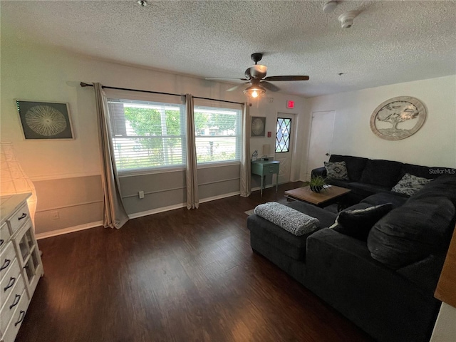 living room with ceiling fan, dark hardwood / wood-style floors, and a textured ceiling