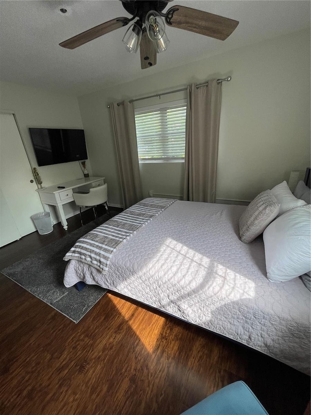 bedroom with ceiling fan, hardwood / wood-style floors, and a textured ceiling