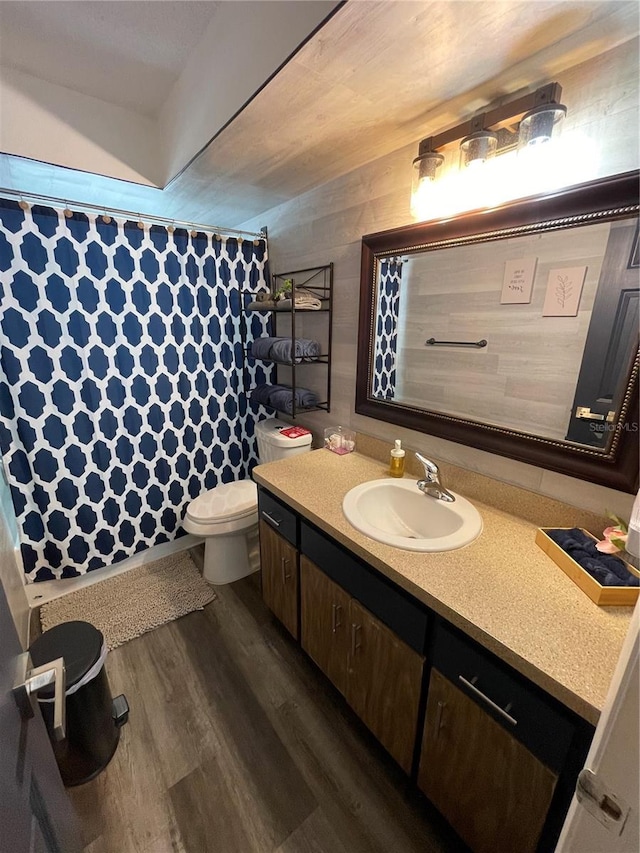 bathroom with a shower with curtain, vanity, hardwood / wood-style floors, and toilet