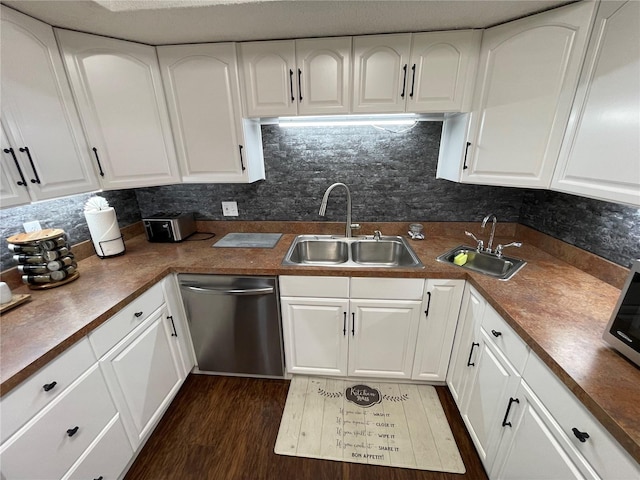 kitchen featuring dark hardwood / wood-style flooring, white cabinetry, sink, and stainless steel dishwasher