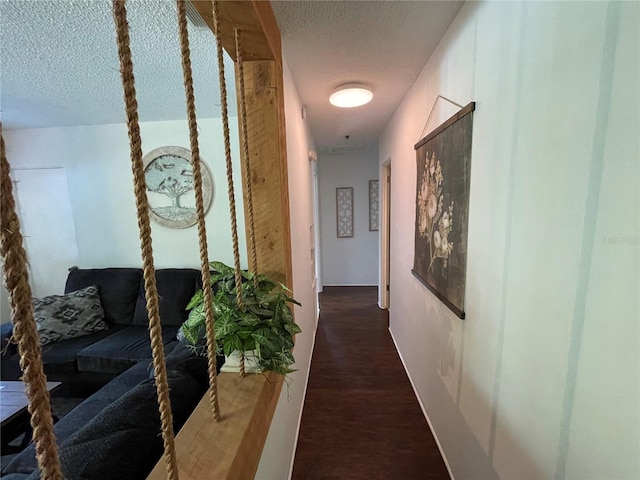 hallway featuring a textured ceiling and dark hardwood / wood-style floors