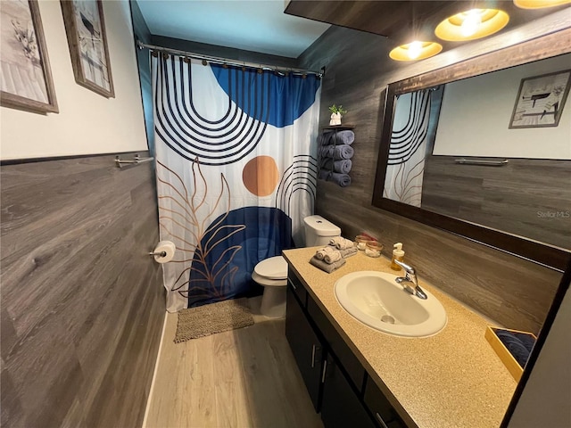 bathroom with curtained shower, vanity, toilet, and hardwood / wood-style flooring