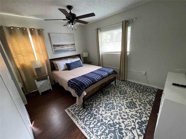 bedroom with a textured ceiling, ceiling fan, and dark hardwood / wood-style flooring