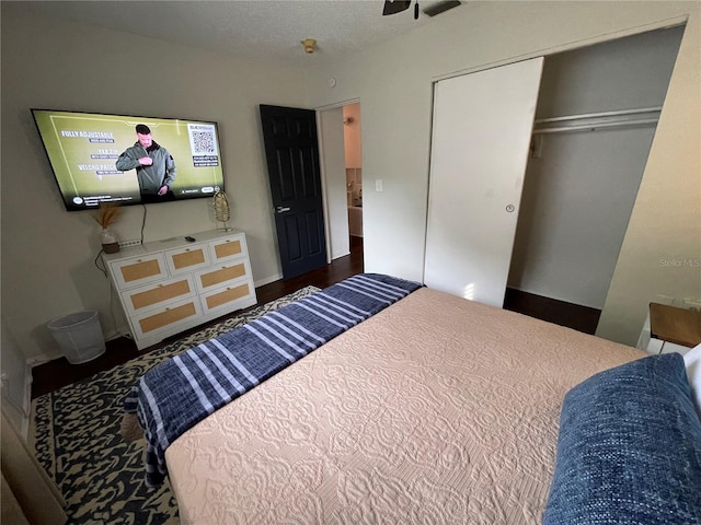 bedroom with a closet, dark wood-type flooring, and a textured ceiling