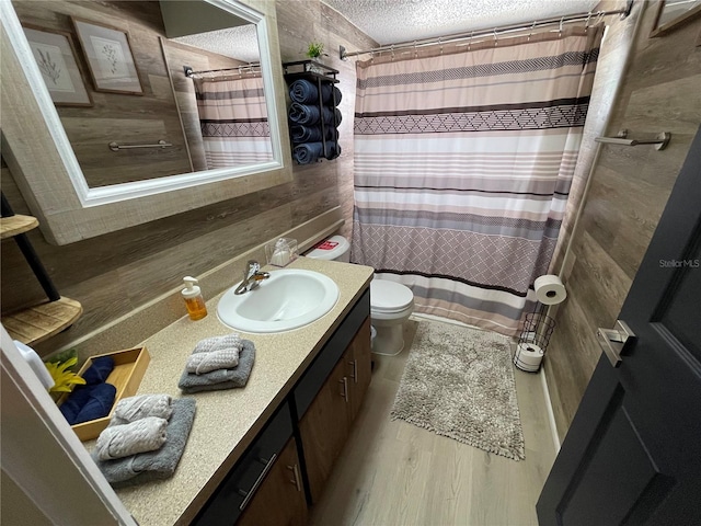 bathroom featuring hardwood / wood-style floors, walk in shower, vanity, and toilet