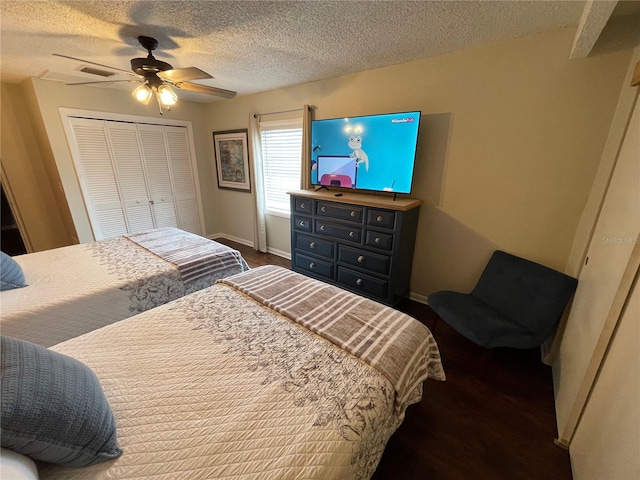 bedroom with a textured ceiling, dark hardwood / wood-style floors, ceiling fan, and a closet