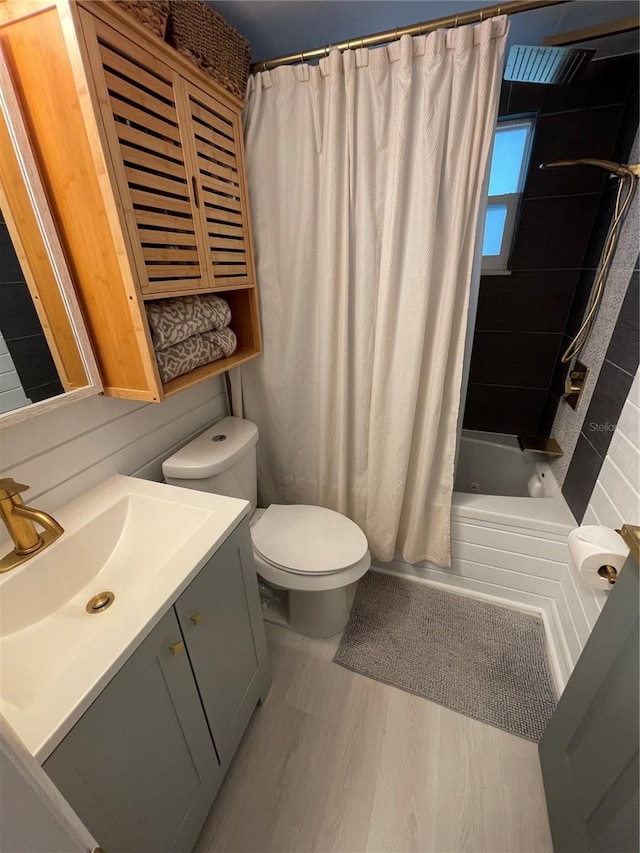 full bathroom with vanity, toilet, hardwood / wood-style flooring, and shower / tub combo with curtain