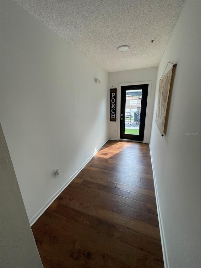 spare room with a textured ceiling and dark hardwood / wood-style flooring