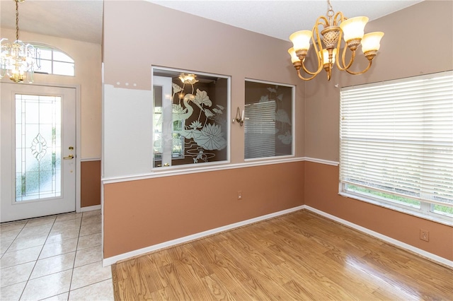 entrance foyer with light hardwood / wood-style flooring and a notable chandelier