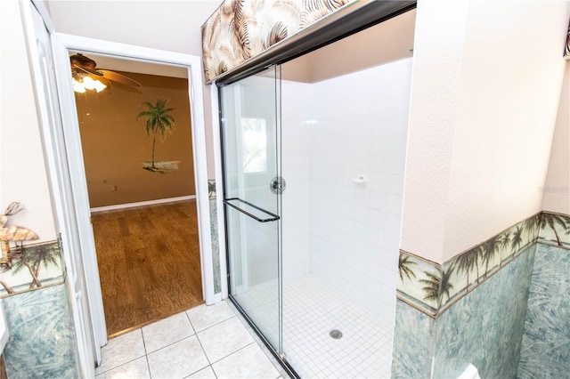 bathroom featuring a shower with door, hardwood / wood-style flooring, and ceiling fan