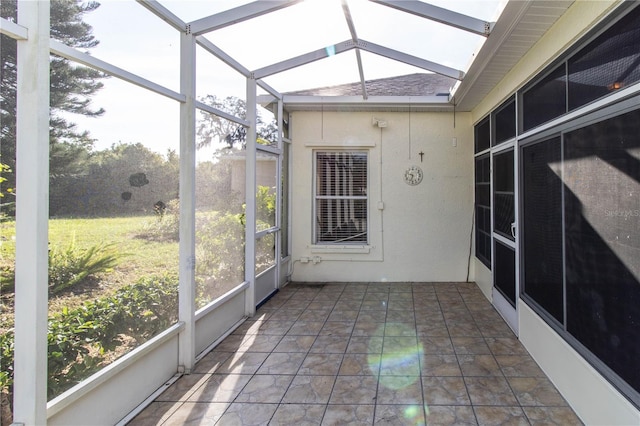 unfurnished sunroom with vaulted ceiling with skylight