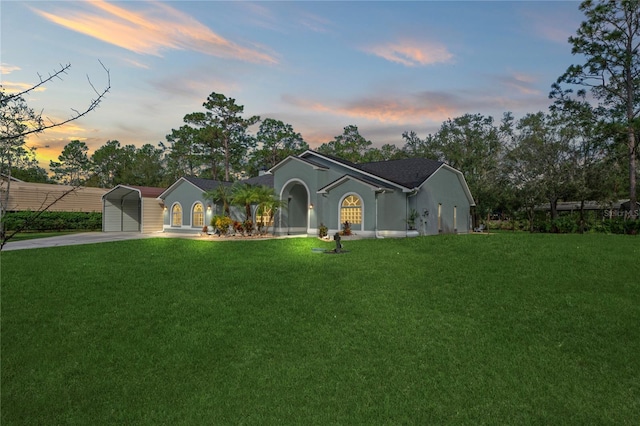 view of front of property with a carport and a yard