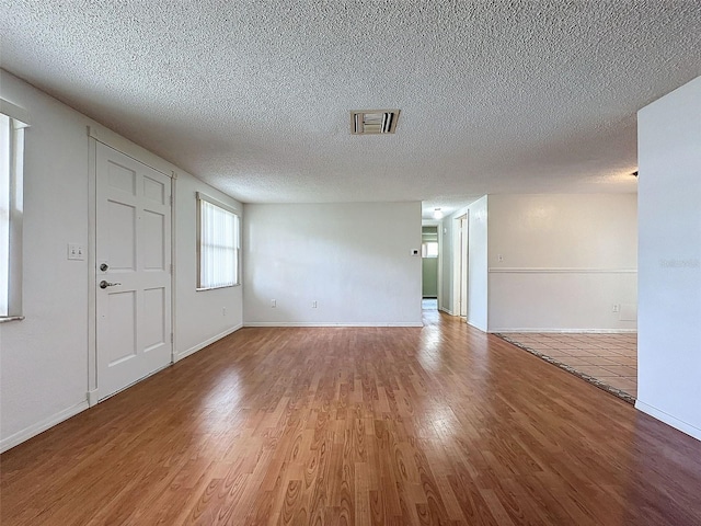 foyer entrance featuring wood-type flooring and a textured ceiling