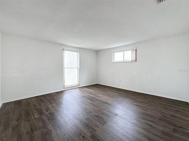 unfurnished room featuring a textured ceiling and dark hardwood / wood-style flooring