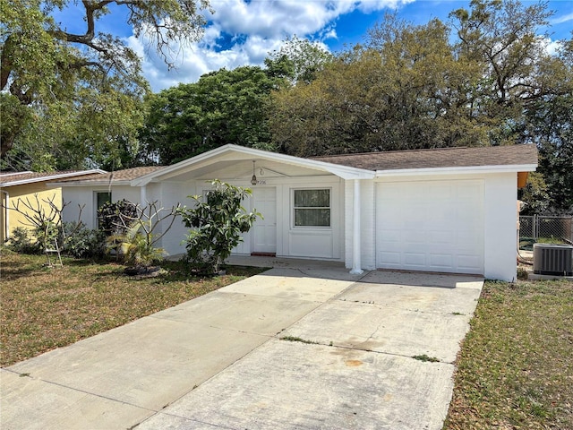 7206 Ashwood Dr, Port Richey, FL 34668 - view of front facade featuring central air condition unit, concrete driveway, an attached garage, a front yard, and stucco siding