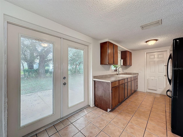 7206 Ashwood Dr, Port Richey, FL 34668 - kitchen featuring freestanding refrigerator, light countertops, a sink, light tile patterned floors, and a textured ceiling