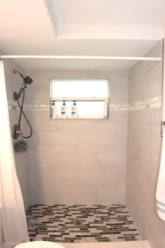 bathroom featuring walk in shower and toilet