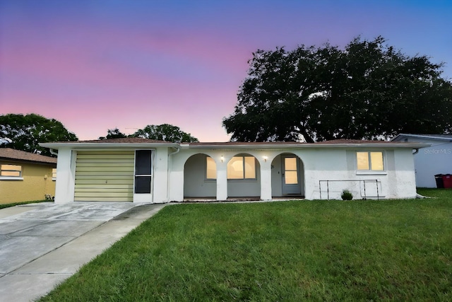 ranch-style house featuring a garage and a yard