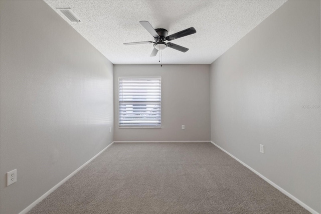 carpeted empty room with ceiling fan and a textured ceiling