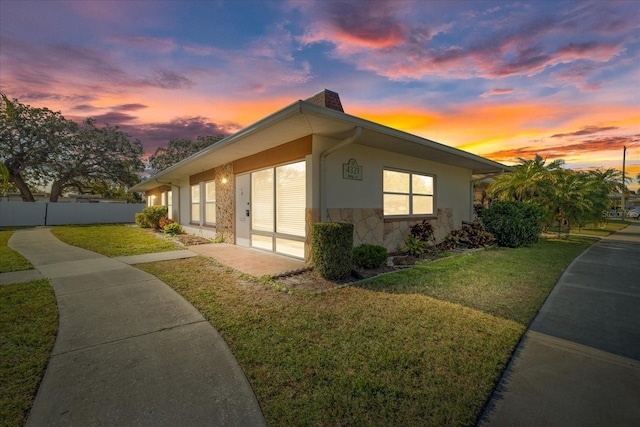 property exterior at dusk with a yard