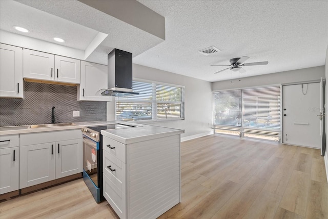 kitchen featuring sink, white cabinetry, stainless steel electric range, and island range hood