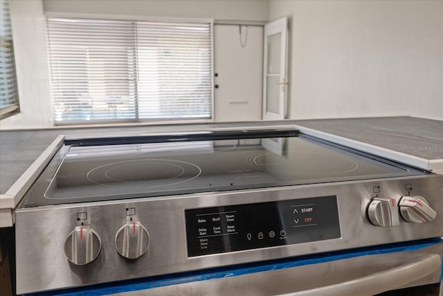 room details with white cabinets and stainless steel range with electric stovetop