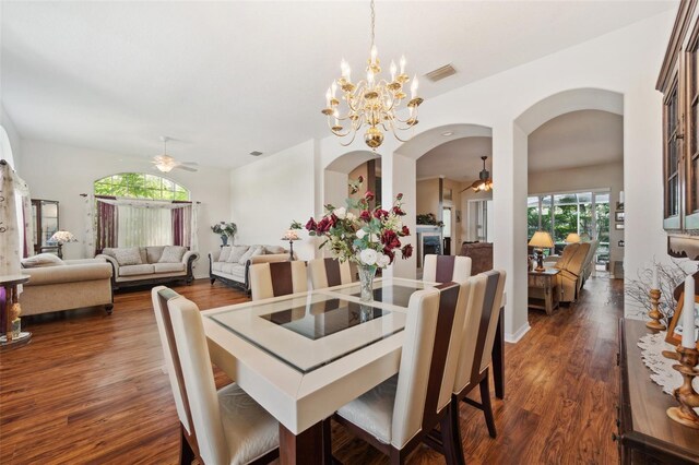 dining area with ceiling fan with notable chandelier and dark hardwood / wood-style flooring