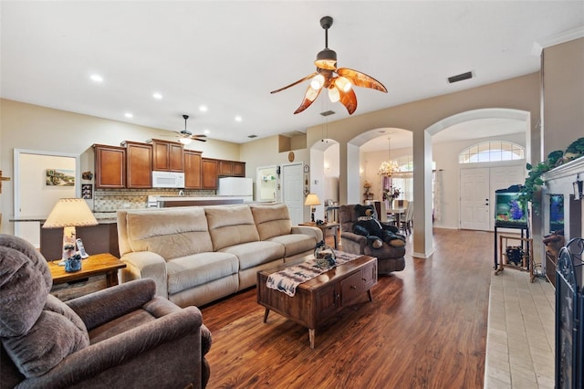 living room featuring ceiling fan with notable chandelier and hardwood / wood-style floors